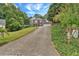 View of a two-story brick home with a long driveway and lawn at 308 Lismore Ter, Woodstock, GA 30189