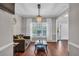 A bright living room featuring hardwood floors, a chandelier, a large window, and neutral paint at 308 Lismore Ter, Woodstock, GA 30189