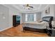 Bedroom features hardwood floors, natural light, and a ceiling fan with a modern tray ceiling at 308 Lismore Ter, Woodstock, GA 30189