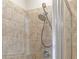 Close up of a shower head with neutral tiling and glass door at 2300 Peachford Rd # 4004, Atlanta, GA 30338