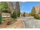 Elegant entrance to a gated community with mature landscaping and brick signage at 2300 Peachford Rd # 4004, Atlanta, GA 30338