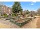 Community garden with raised beds, mature trees, and an area for relaxing at 2300 Peachford Rd # 4004, Atlanta, GA 30338