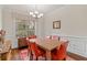 A sunlit dining room with hardwood floors, bright orange chairs, and classic trim at 2300 Peachford Rd # 4004, Atlanta, GA 30338