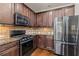 A well-equipped kitchen featuring dark wood cabinets, stainless steel appliances, and granite countertops at 2300 Peachford Rd # 4004, Atlanta, GA 30338