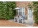 Private patio with four chairs, small table, and a view of the lush landscaping at 2300 Peachford Rd # 4004, Atlanta, GA 30338