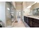 Bright bathroom featuring a walk-in glass shower, double vanity with granite counters, and neutral toned tile flooring at 3152 Avenel Ct, Snellville, GA 30078