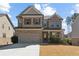 Charming two-story brick home with a well-manicured lawn and attached two-car garage in a suburban neighborhood at 3152 Avenel Ct, Snellville, GA 30078