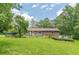 Large backyard with a mix of green space and mature trees, providing a private and serene outdoor environment at 5255 Post Rd, Winston, GA 30187