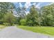 Long, winding driveway leading to a secluded property surrounded by mature trees and a well-manicured lawn at 5255 Post Rd, Winston, GA 30187