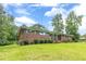 Charming brick home with a covered porch, surrounded by a well-manicured lawn and mature landscaping at 5255 Post Rd, Winston, GA 30187