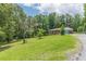 Scenic view of a brick home with an attached garage, set on a large lot with mature trees and lush lawn at 5255 Post Rd, Winston, GA 30187