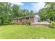 Charming brick home with a well-maintained lawn and mature trees, creating a serene setting at 5255 Post Rd, Winston, GA 30187