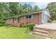 A classic brick home with a cozy front porch and colorful shutters, surrounded by lush greenery at 5255 Post Rd, Winston, GA 30187