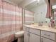 Bathroom featuring a vanity with sink, toilet, mirror, and shower with decorative pink curtain at 3465 Jones Ferry Ln, Alpharetta, GA 30022