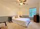 Well-lit bedroom with a bed, a wooden side table, and views of greenery from the window at 3465 Jones Ferry Ln, Alpharetta, GA 30022