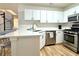 Contemporary kitchen with stainless steel appliances, quartz countertops, white cabinets, and stylish breakfast bar at 3465 Jones Ferry Ln, Alpharetta, GA 30022
