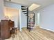 Well-lit living room featuring a decorative spiral staircase, grand piano, and wood floors at 3465 Jones Ferry Ln, Alpharetta, GA 30022
