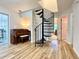 Inviting living room features an elegant spiral staircase, piano, and wood floors throughout at 3465 Jones Ferry Ln, Alpharetta, GA 30022