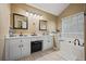 Bathroom with double sinks, white cabinets, soaking tub, and framed mirrors at 129 Windy Cir, Mcdonough, GA 30253
