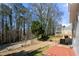 View of a spacious backyard with a deck, patio, and wooded area beyond at 2740 Woodbine Hill Way, Norcross, GA 30071