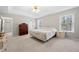 Bright main bedroom featuring neutral tones, soft carpet, and natural light from two windows at 2740 Woodbine Hill Way, Norcross, GA 30071