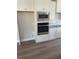 White kitchen features stainless appliances, a built-in microwave, and a decorative backsplash at 3076 Zodiac Ct, Lawrenceville, GA 30044