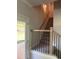 Carpeted staircase with wooden railings, and natural light flowing in from a nearby doorway at 3076 Zodiac Ct, Lawrenceville, GA 30044