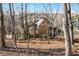 Back of house, framed by trees, with a glimpse of the landscaped yard, hot tub and patio at 4411 Windsor Oaks Cir, Marietta, GA 30066