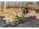 Landscaped backyard featuring a tiered rock waterfall and lush plant life at 4411 Windsor Oaks Cir, Marietta, GA 30066