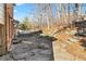 Stone patio with stairs leading up to a beautiful backyard and natural retaining wall at 4411 Windsor Oaks Cir, Marietta, GA 30066