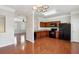Open concept kitchen with dark wood cabinets, black appliances and hardwood floors at 622 Providence Sw Pl, Atlanta, GA 30331