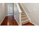 Carpeted staircase with white railing and hardwood flooring in the entry way at 622 Providence Sw Pl, Atlanta, GA 30331