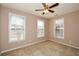 Cozy bedroom with carpet flooring, three windows providing natural light, and a ceiling fan at 1130 Camry Cir, Dallas, GA 30157