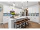Bright kitchen featuring white cabinets, a quartz countertop island with bar seating, and a stylish blue tile backsplash at 145 Silver Leaf Trce, Douglasville, GA 30134