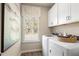 Functional laundry room featuring modern washer and dryer, ample cabinet space, and a window for natural light at 145 Silver Leaf Trce, Douglasville, GA 30134
