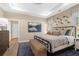 Comfortable main bedroom with a tray ceiling, a dark metal bed frame, and a decorative blue rug at 145 Silver Leaf Trce, Douglasville, GA 30134
