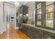 Stylish bar area with dark cabinets, marble countertops, mirrored backsplash, and hardwood flooring at 3977 Sweet Bottom Dr, Duluth, GA 30096