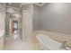 Elegant bathroom with a modern shower, a classic soaking tub, and neutral walls over tile flooring at 3977 Sweet Bottom Dr, Duluth, GA 30096