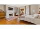 Cozy bedroom with hardwood floors, a decorative fireplace, and a large window for natural light at 3977 Sweet Bottom Dr, Duluth, GA 30096