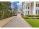 Elegant white home featuring black shutters, large columns, and an expansive driveway leading to a detached garage at 3977 Sweet Bottom Dr, Duluth, GA 30096