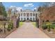 Grand estate featuring a gated entrance and impressive brick driveway leading to a columned facade and manicured landscaping at 3977 Sweet Bottom Dr, Duluth, GA 30096