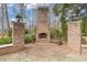 Charming outdoor fireplace area with brick surround and stone accents at 3977 Sweet Bottom Dr, Duluth, GA 30096
