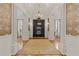 Elegant foyer featuring hardwood floors, detailed columns, a chandelier, and a view of the grand double doors at 3977 Sweet Bottom Dr, Duluth, GA 30096
