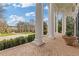 Elegant porch with white columns frames a manicured lawn, providing a serene and picturesque view of the lush surroundings at 3977 Sweet Bottom Dr, Duluth, GA 30096