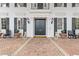 Elegant entryway showcasing double doors, decorative columns, and a charming brick porch adorned with planters and dog statues at 3977 Sweet Bottom Dr, Duluth, GA 30096