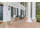 Inviting front porch features a brick floor, white columns, black shutters, and dog statues flanking the double door entrance at 3977 Sweet Bottom Dr, Duluth, GA 30096