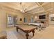 Entertaining game room featuring billiards tables, stone fireplace, and elegant lighting at 3977 Sweet Bottom Dr, Duluth, GA 30096