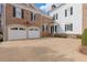 View of a detached brick garage with white doors and a connecting section to the main house, highlighting ample parking at 3977 Sweet Bottom Dr, Duluth, GA 30096