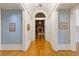 Hallway with barrel ceiling and chandelier leads to the dining room with fireplace at 3977 Sweet Bottom Dr, Duluth, GA 30096