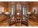 Comfortable home office with leather seating, wood paneling, and hardwood floors at 3977 Sweet Bottom Dr, Duluth, GA 30096